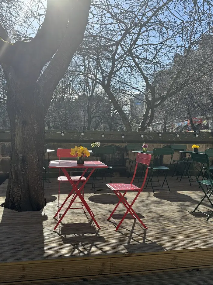 Red bistro table with daffodils on the garden terrace