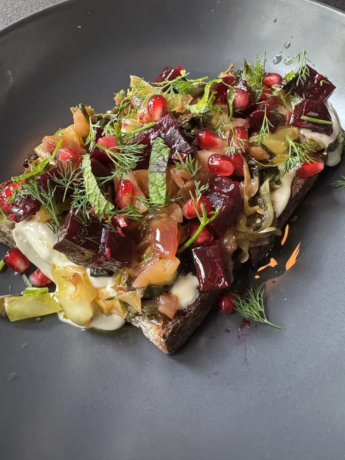 Toast piled with beetroot, pomegranate, dill and cashew cream