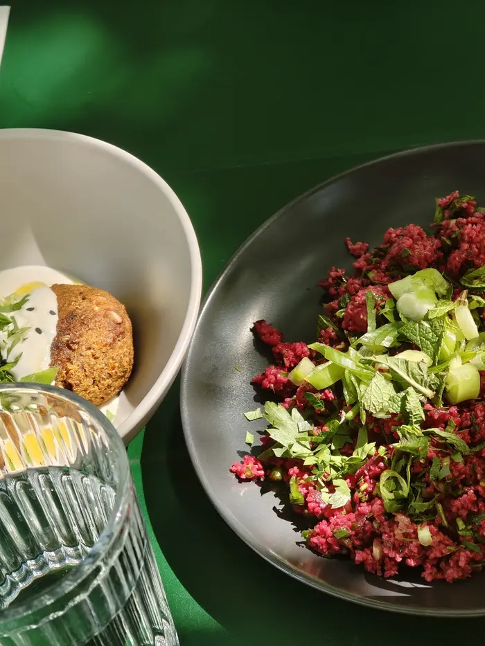 Falafel with cashew cream and a beetroot bulgur salad on a green table